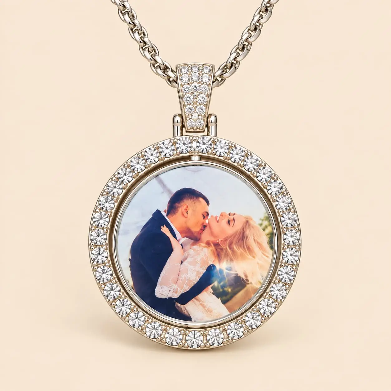 An elegant round pendant features a silver-tone alloy frame decorated with sparkling rhinestone accents