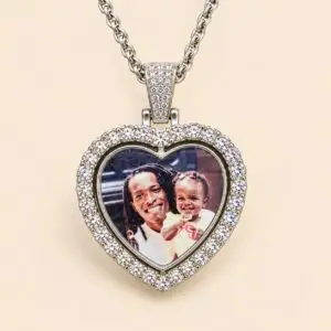An elegant heart-shaped pendant features a silver-tone alloy frame decorated with sparkling rhinestone accents